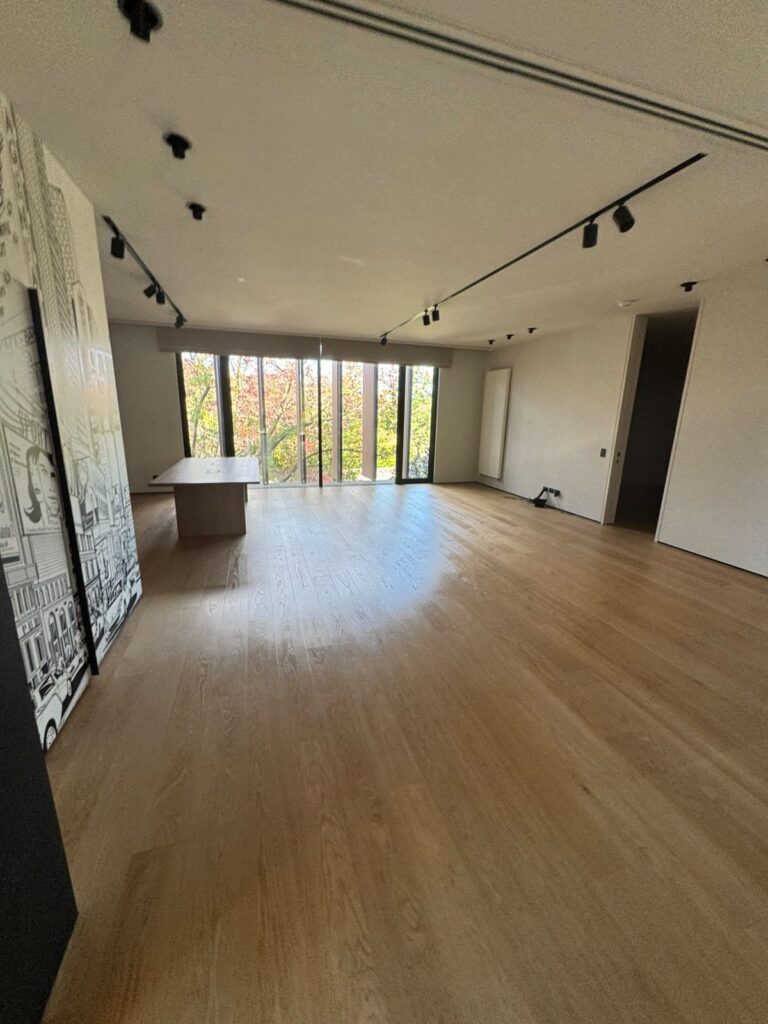 Freshly painted off-white interior walls in a Toorak living room with timber floors and floor-to-ceiling windows